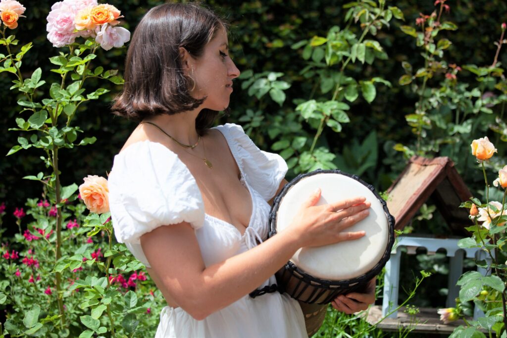 Woman in white dress with djembe