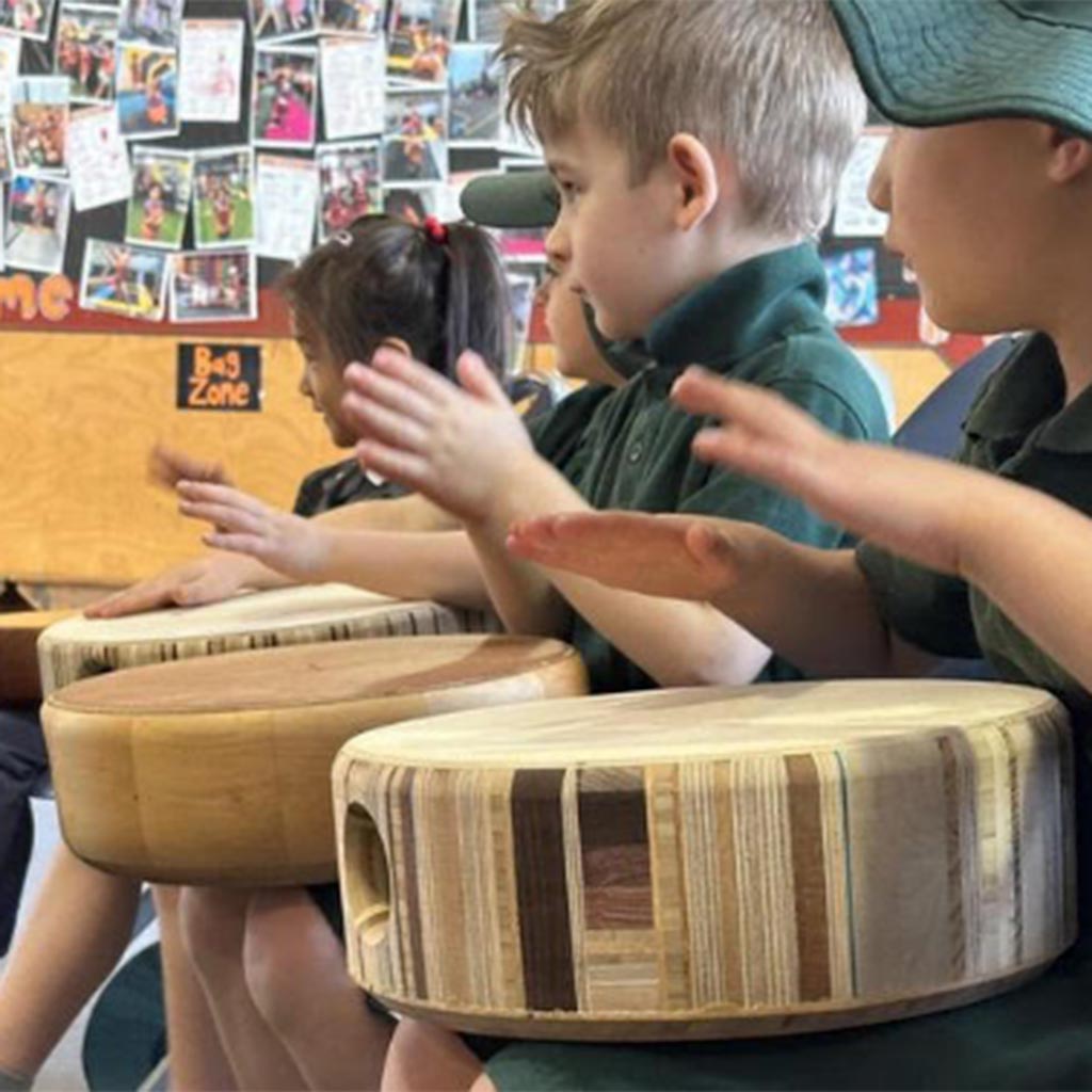 young children in kinder playing cajon drums at a workshop