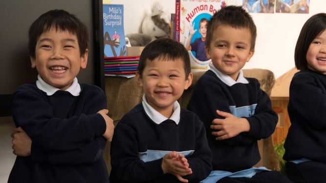 a group of boys in school uniforms playing djembe in an african drumming incursion