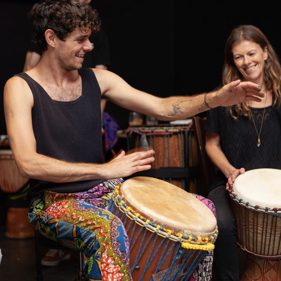 teacher playing djembe in an African drumming class in St Kilda, Melbourne with students enjoying the session