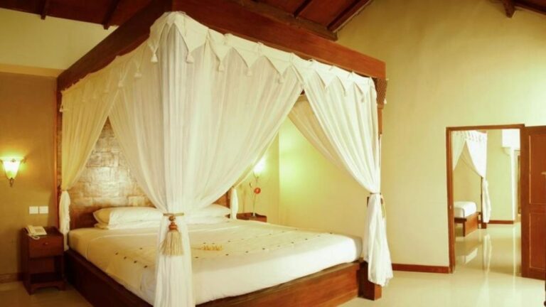 Spacious accommodation room with a canopy bed at the African Drumming Bali Drum Camp retreat venue.