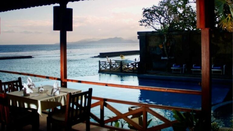 Oceanfront dining area at the venue for African Drumming’s Bali Drum Camp, overlooking the sea and pool at sunset.