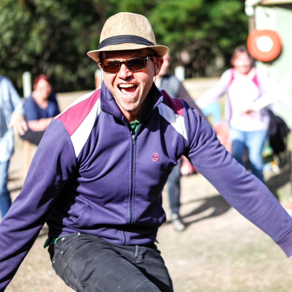 Simon dancing and leading a lively session at the Spring Drum and Dance Retreat, engaging participants in rhythm and movement.