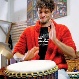 African Drumming teacher demonstrating djembe techniques to students
