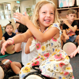 Kinder kids interacting and playing together in an African Drumming session