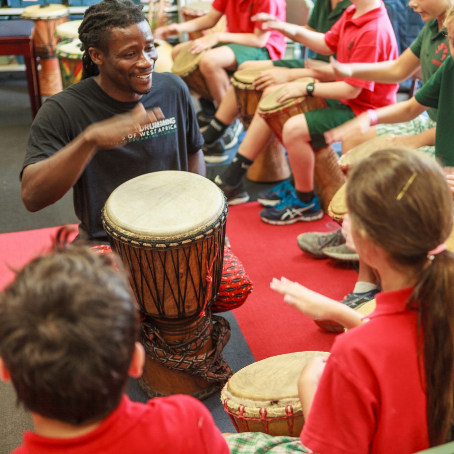 African Drumming facilitator leads a primary school class in West African percussion using djembes.