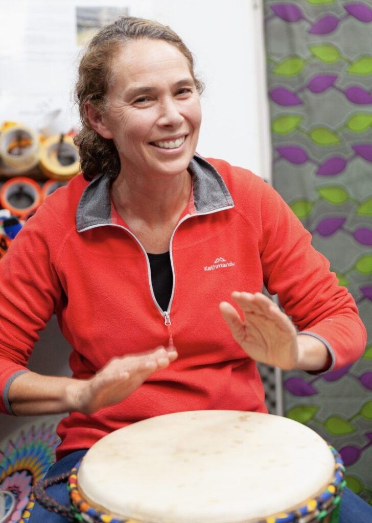 a woman playing the djembe in a private drumming class in melbourne