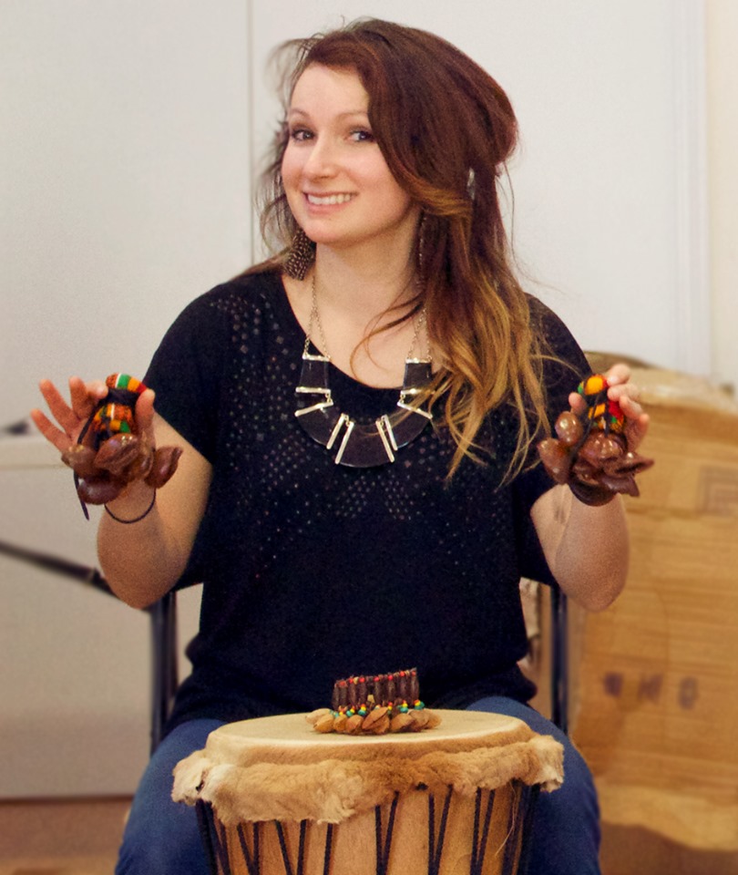 a facilitator with a djembe holding a shaker at and african drumming facilitator training