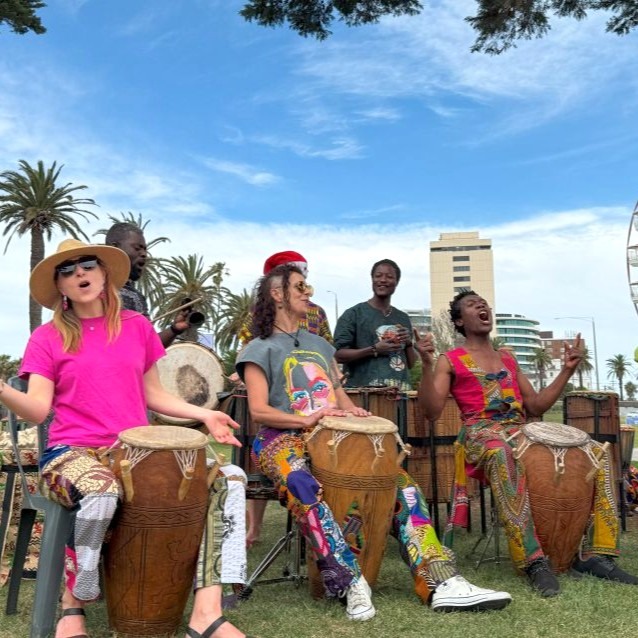 African Drumming students happily vocalising while playing drums during class performance