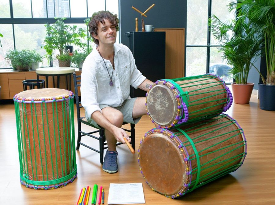 Student playing West African dundun drums in a specialty drumming class