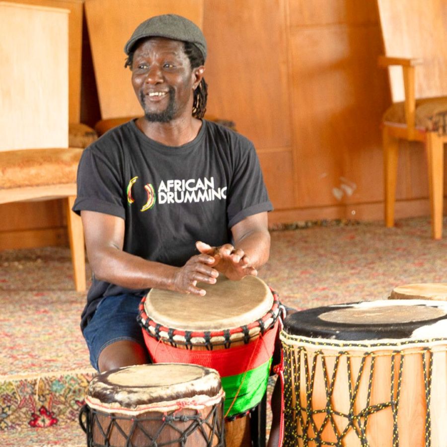 Yaw Asumadu, instructor at the nz rum camp, sitting with his djembe