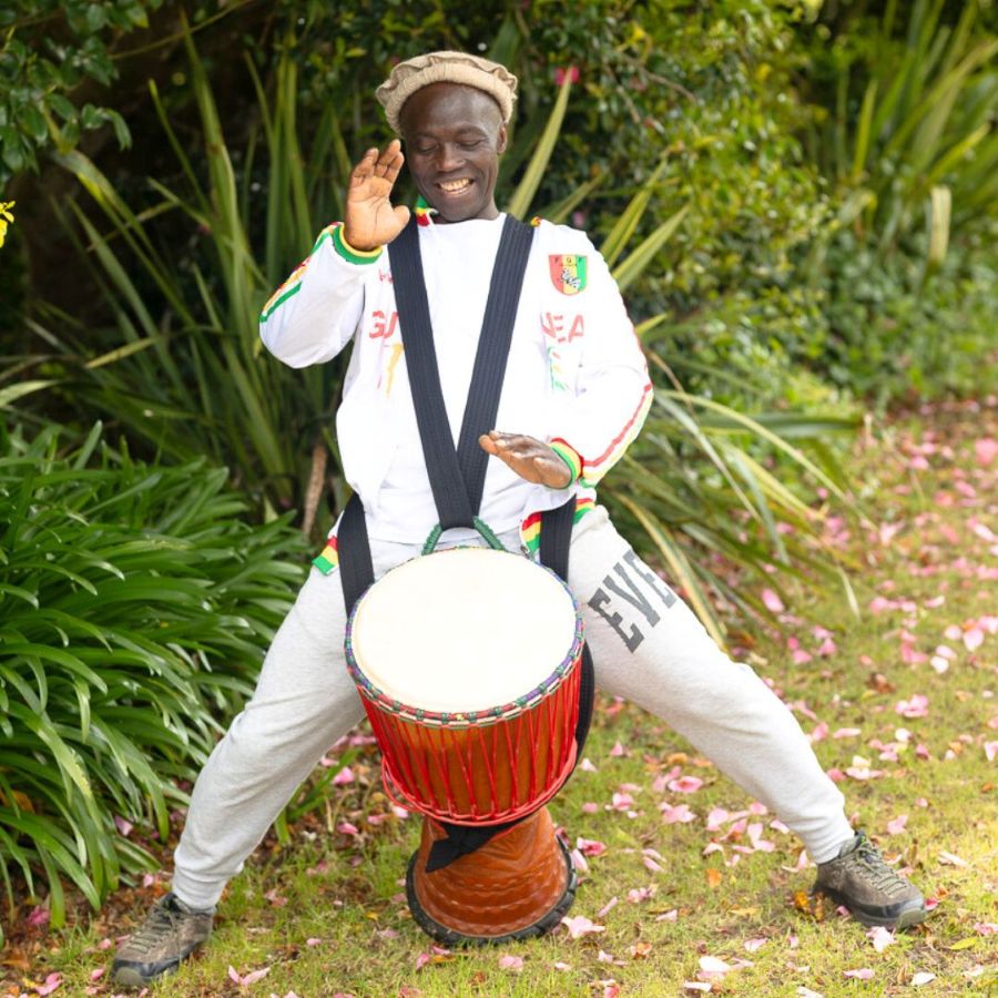 Epizo Bangoura, teacher at the nz rum and dance camp, standing and playing with his djembe