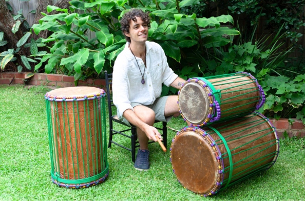 a drummer playing african dununs in the park