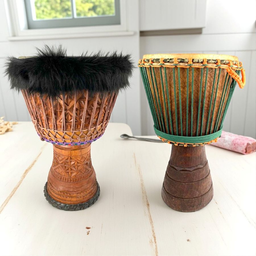 Two Primo Series djembes with detailed carvings and rope tuning, handcrafted from West African hardwoods.