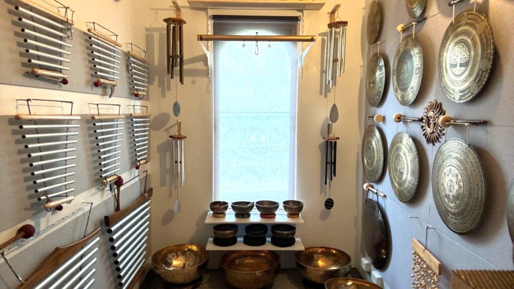 Sonora Studio sound healing room in St Kilda with gongs, singing bowls, and chimes displayed along the walls, creating a peaceful space for exploration and meditation.