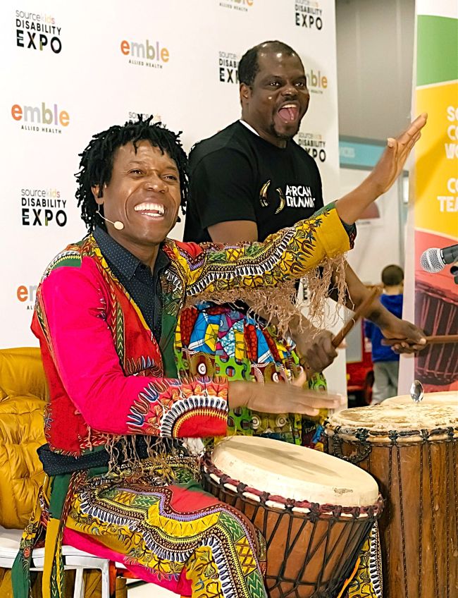 African drumming facilitators playing djembes during an all abilities workshop at the Disability Expo