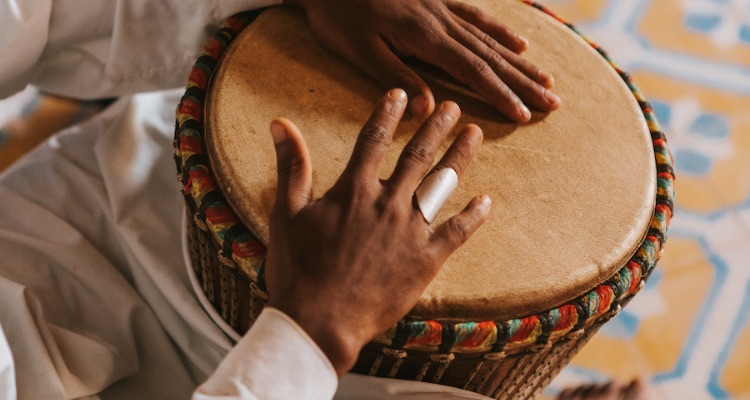 Close-up of a handcrafted djembe drum with carved hardwood body and natural skin head.