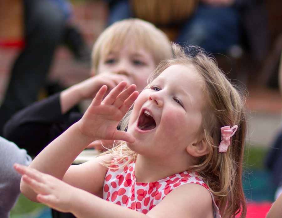 Young primary school student singing and clapping during an African singing workshop